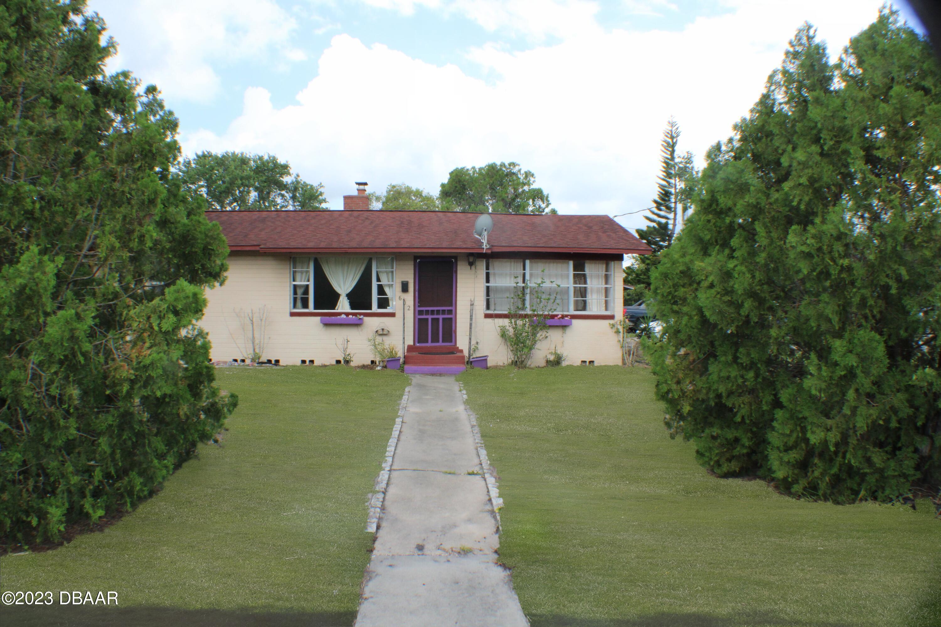 602 Flagler Avenue Edgewater, FL 32132 - Photo 4 of 15 a front view of a house with a garden