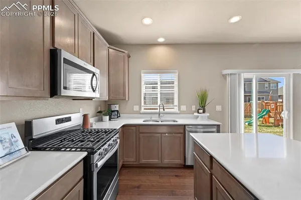 a kitchen with stainless steel appliances granite countertop a sink stove and cabinets