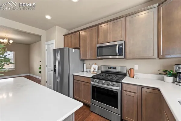 a kitchen with stainless steel appliances a stove microwave and sink