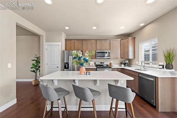 a kitchen with granite countertop a center island a sink cabinets and appliances