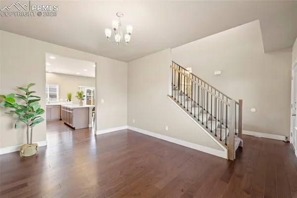 a view of a hallway with wooden floor and a potted plant