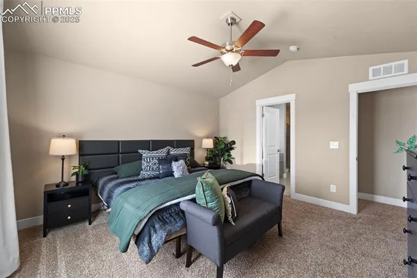 a bedroom with a bed a couch and a potted plant