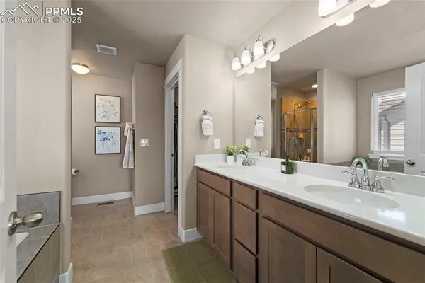 a spacious bathroom with a double vanity sink a mirror and a shower
