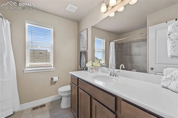 a bathroom with a double vanity sink toilet and a mirror