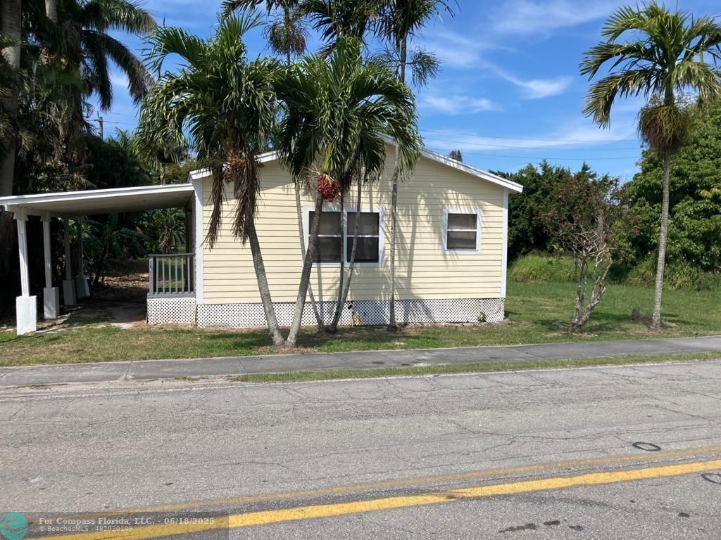 179 South Barfield Highway, Unit 1 Pahokee, FL 33476 - Photo 2 of 19 a front view of a house with a yard and garage
