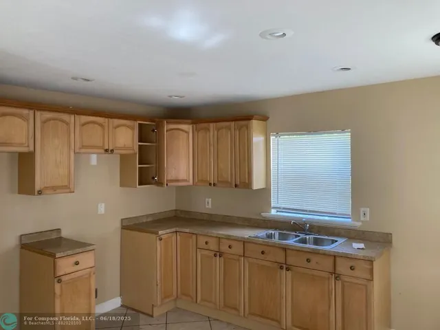 a kitchen with granite countertop white cabinets and sink