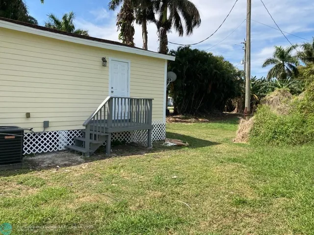 a view of a house with a yard and wooden fence