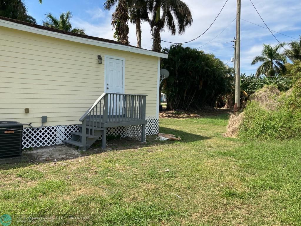 179 South Barfield Highway, Unit 1 Pahokee, FL 33476 - Photo 6 of 19 a view of a house with a yard and wooden fence