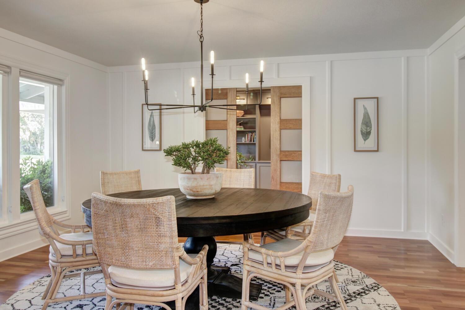 a dining room with furniture a chandelier and wooden floor