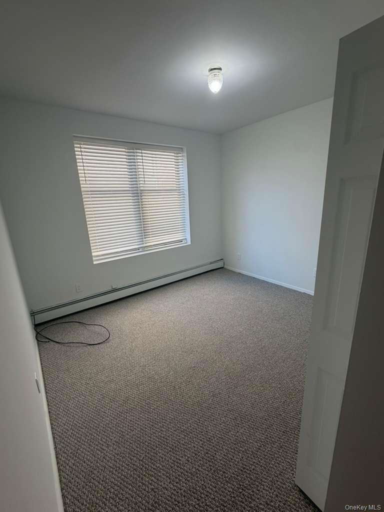 663 92nd Street Brooklyn, NY 11228 - Photo 5 of 6 an empty room with a empty space and windows