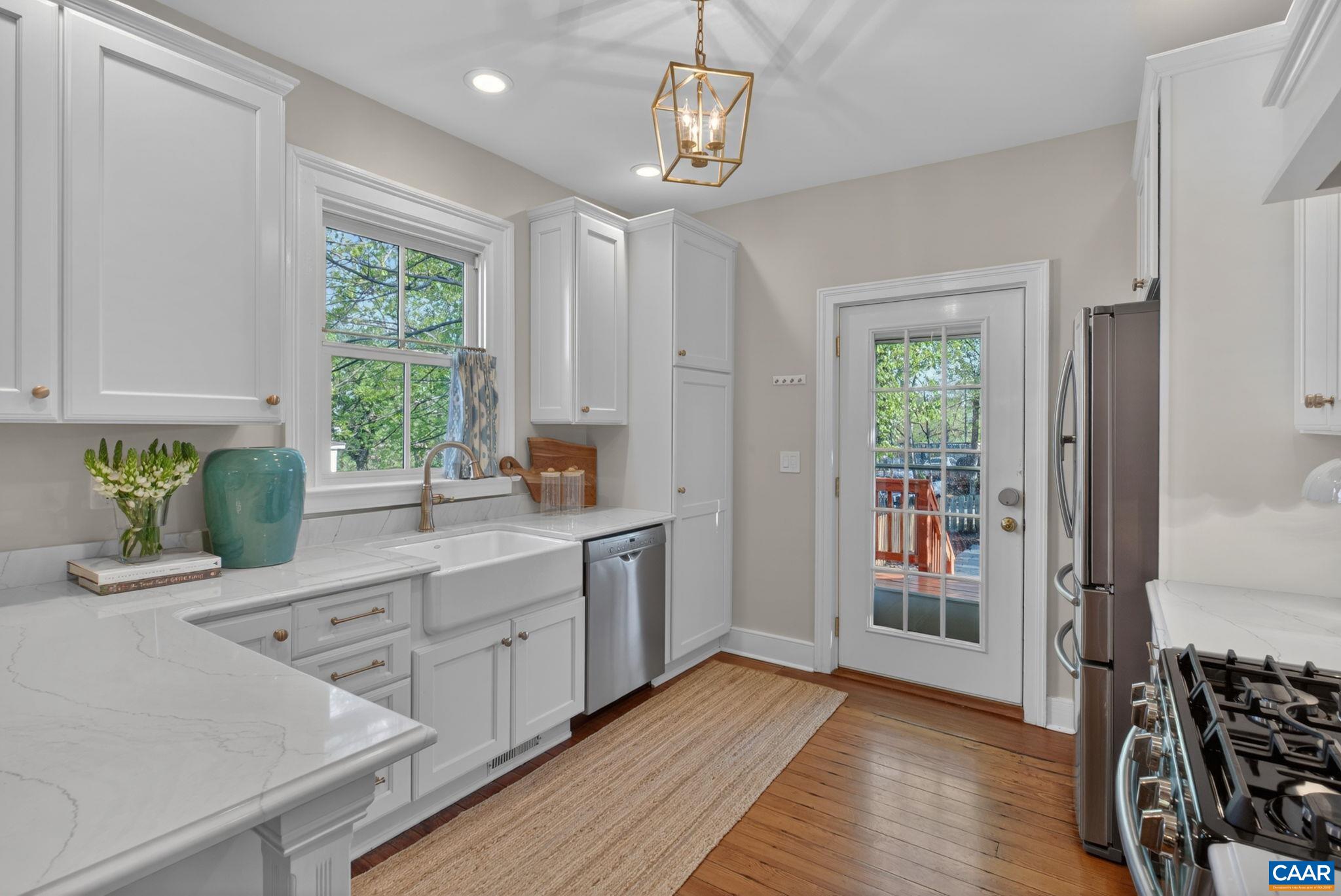 623 Hinton Avenue Charlottesville, VA 22902 - Photo 13 of 35 a kitchen with stainless steel appliances granite countertop a stove a sink and a refrigerator with wooden floor