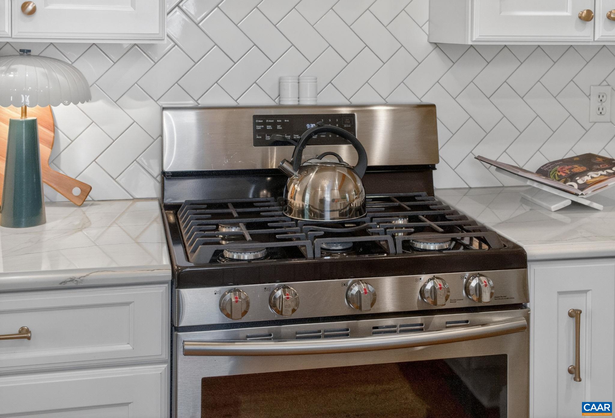 623 Hinton Avenue Charlottesville, VA 22902 - Photo 16 of 35 a stove sitting inside of a kitchen with white cabinets