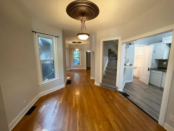 a view of a living room with wooden floor and chandelier