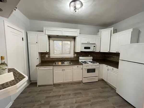 a kitchen with stainless steel appliances granite countertop a sink and a stove