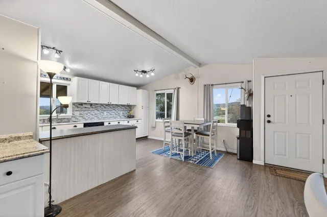 a kitchen with a refrigerator a stove top oven a dining table and chairs