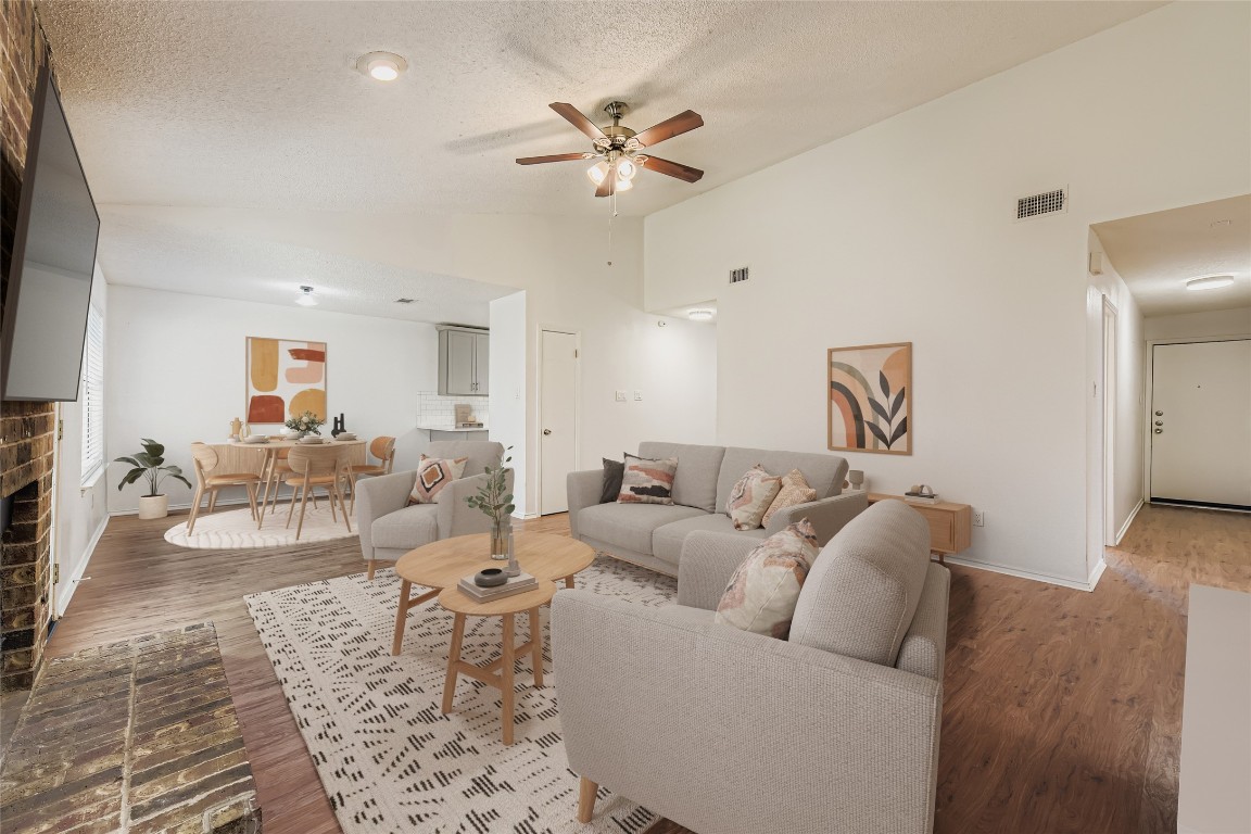 9839 Briar Ridge Drive Austin, TX 78748 - Photo 13 of 28 Living area with vaulted ceiling, wood finished floors, a fireplace, a textured ceiling, and ceiling fan