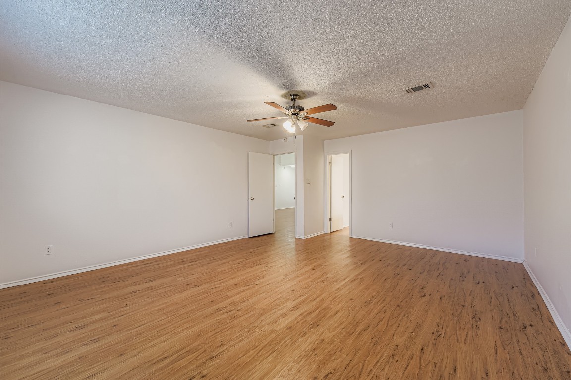 9839 Briar Ridge Drive Austin, TX 78748 - Photo 20 of 28 Unfurnished room with a textured ceiling, light wood-style floors, and ceiling fan