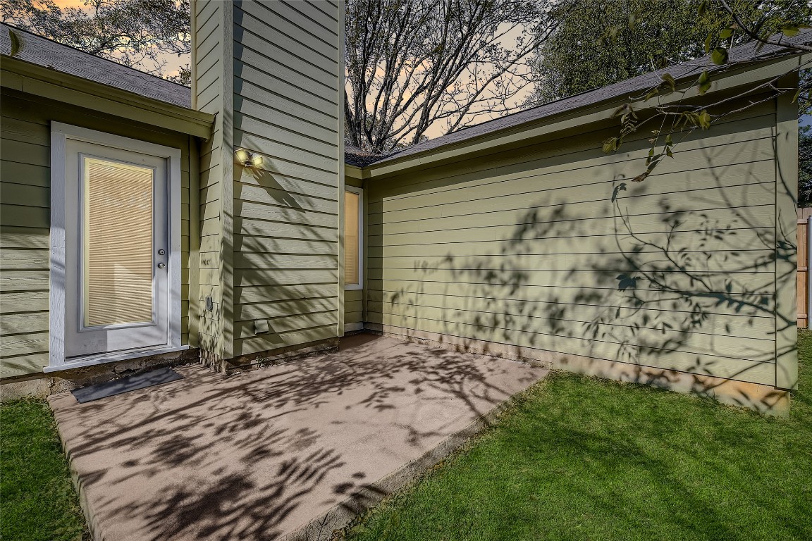 9839 Briar Ridge Drive Austin, TX 78748 - Photo 26 of 28 View of side of home featuring a patio, roof with shingles, and a lawn