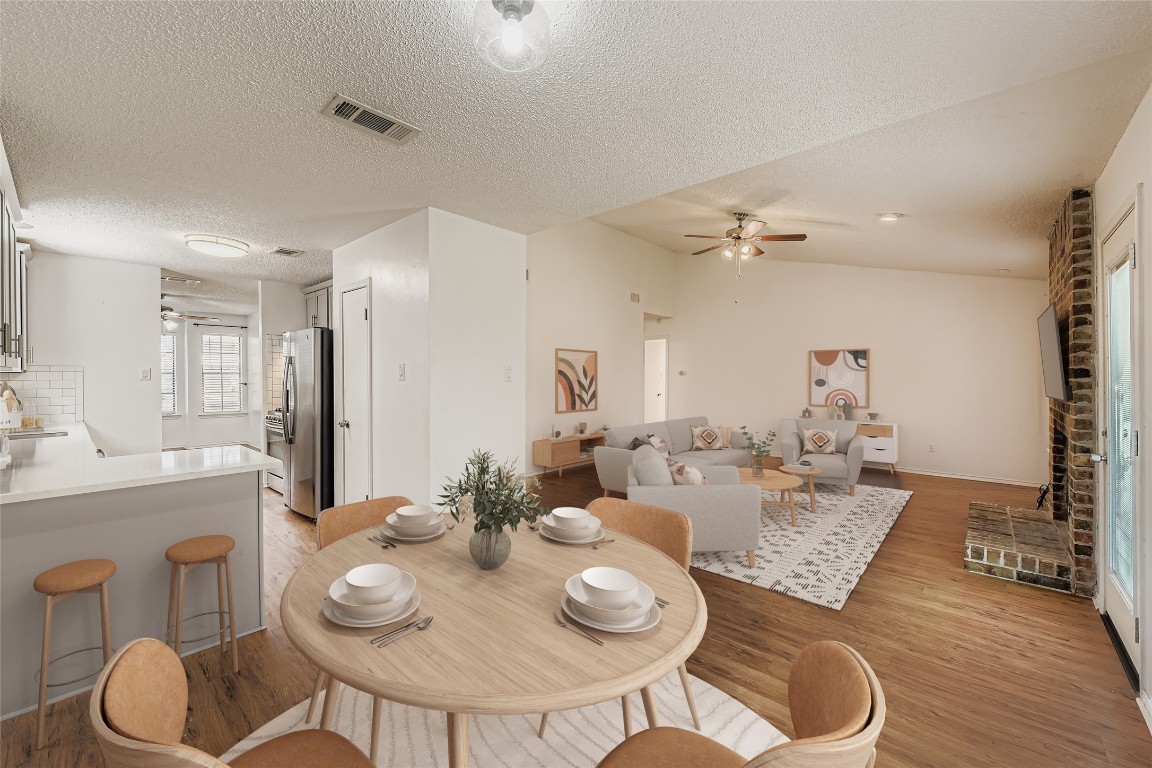 9839 Briar Ridge Drive Austin, TX 78748 - Photo 8 of 28 Dining space featuring lofted ceiling, light wood-style floors, a ceiling fan, and a textured ceiling