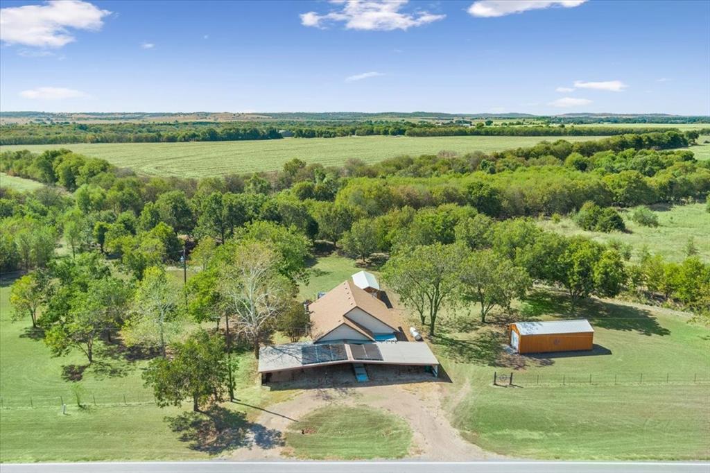4246 Old Caufield Ranch Road McGregor, TX 76657 - Photo 3 of 31 Expansive property featuring a single-story residence, a detached storage building, a covered carport, mature trees, and open fields