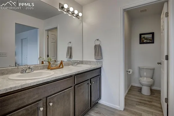 a bathroom with a granite countertop sink a toilet and a mirror