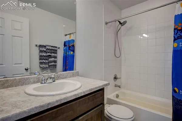 a bathroom with a granite countertop sink a toilet and shower