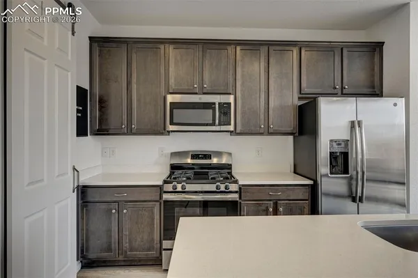 a kitchen with wooden cabinets and stainless steel appliances