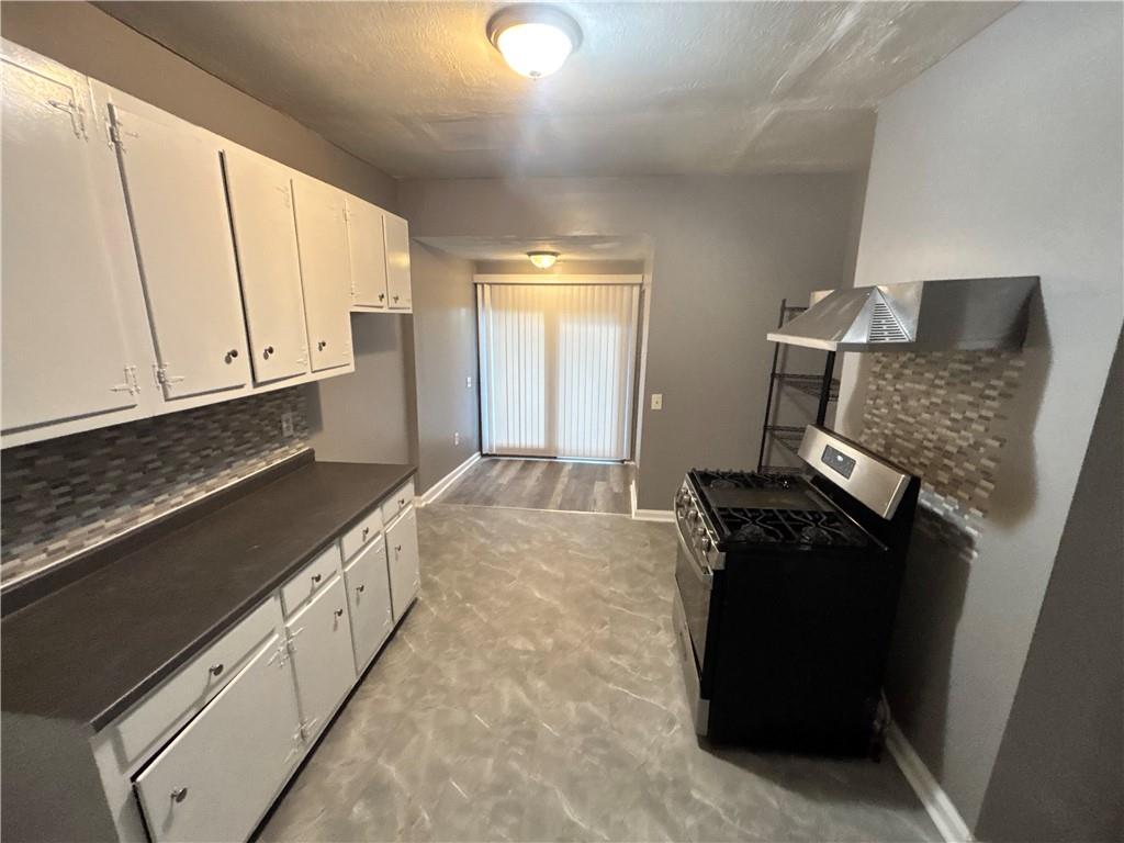 335 Cedarhurst Street Pittsburgh, PA 15210 - Photo 14 of 28 a kitchen with granite countertop a stove and a refrigerator