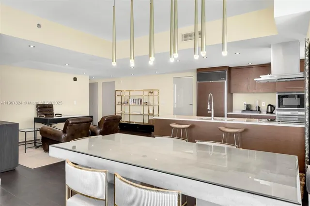 a open kitchen with stainless steel appliances kitchen island granite countertop a table and chairs in it