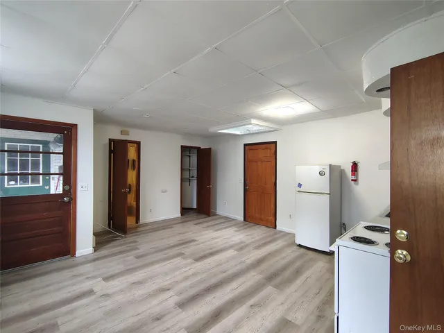 a view of empty room with wooden floor and windows