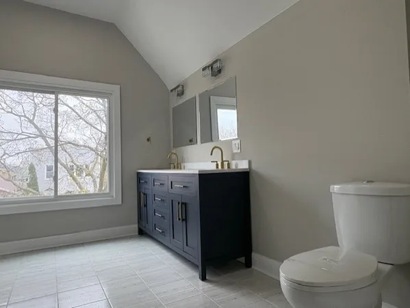 a bathroom with a sink vanity mirror and toilet