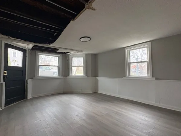 a view of an empty room with wooden floor and windows