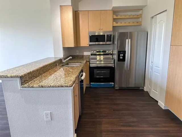 a kitchen with granite countertop a refrigerator and a stove