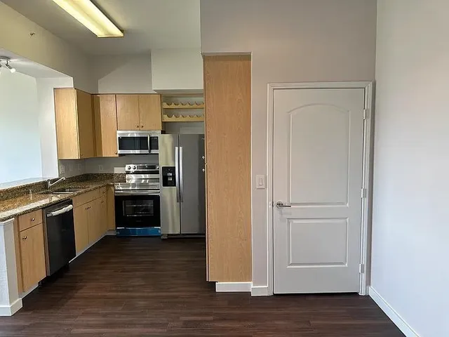 a kitchen with stainless steel appliances granite countertop a refrigerator and a stove top oven