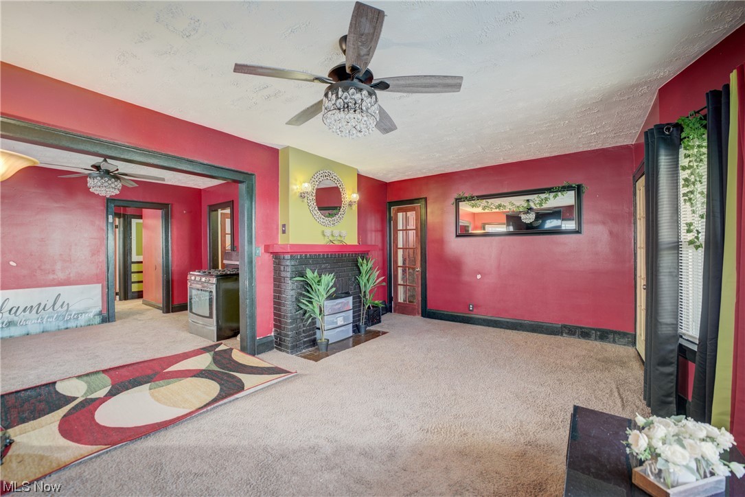14202 Glenside Road Cleveland, OH 44110 - Photo 27 of 41 Carpeted living room with ceiling fan and a textured ceiling