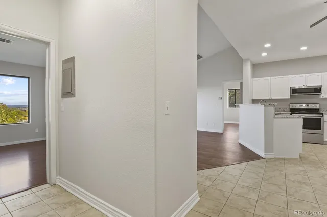 a view of a kitchen with wooden floor and electronic appliances