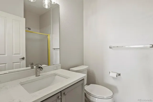 a bathroom with a sink vanity mirror and toilet