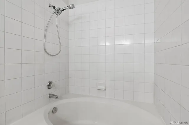 a bathroom with a bath tub with a shower
