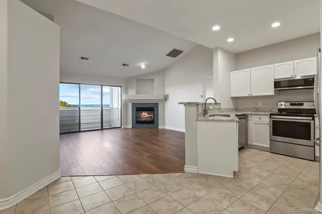 a kitchen with granite countertop a stove top oven and cabinets