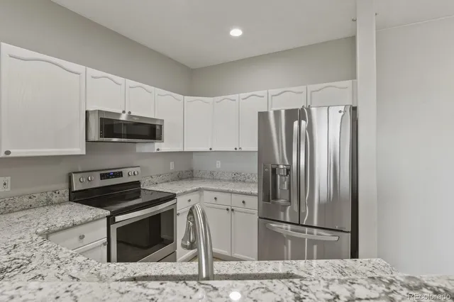 a kitchen with stainless steel appliances granite countertop a refrigerator stove and microwave