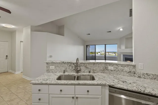 a kitchen with granite countertop a sink and cabinets