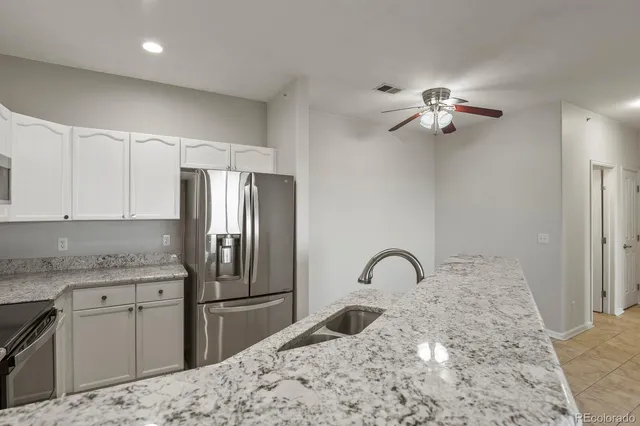 a kitchen with a refrigerator sink and cabinets
