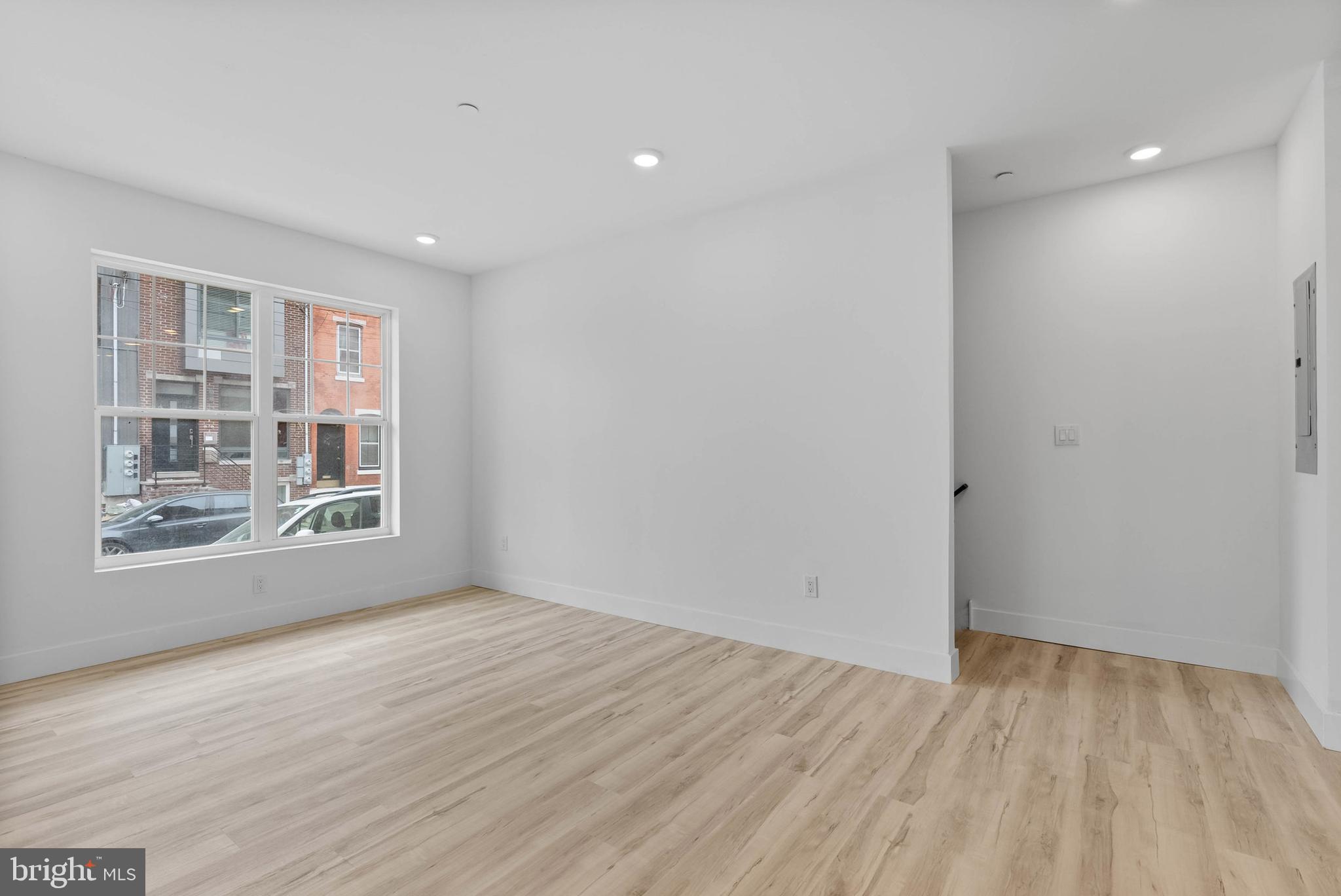 809 Diamond Street, Unit A101 Philadelphia, PA 19122 - Photo 4 of 17 a view of an empty room with wooden floor and a window
