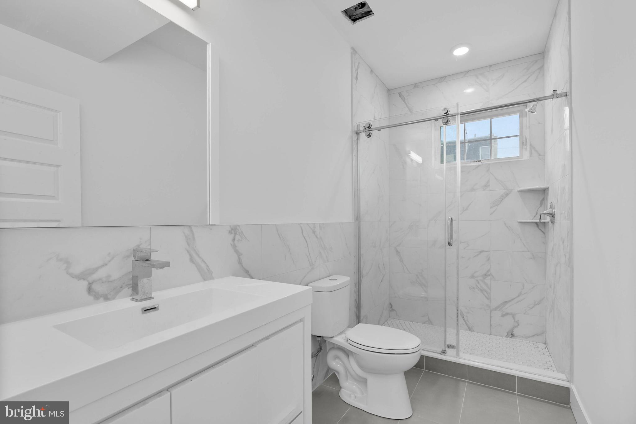809 Diamond Street, Unit A101 Philadelphia, PA 19122 - Photo 7 of 17 a bathroom with a sink toilet and shower