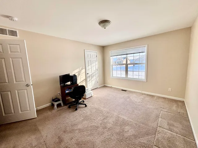 a view of a workspace with furniture and a window