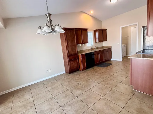 a large kitchen with kitchen island granite countertop a sink a counter space and cabinets