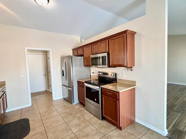 a kitchen with stainless steel appliances granite countertop a stove a sink and a refrigerator