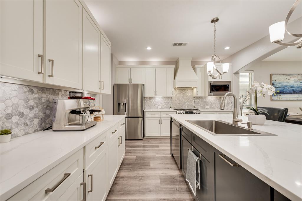 920 Sheldon Road Argyle, TX 76226 - Photo 5 of 36 Modern kitchen featuring white shaker cabinetry and a contrasting dark gray island
