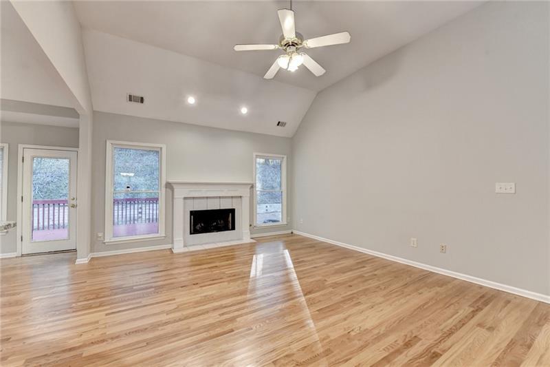 655 Golden Meadows Lane Suwanee, GA 30024 - Photo 11 of 73 wooden floor fireplace and windows in an empty room