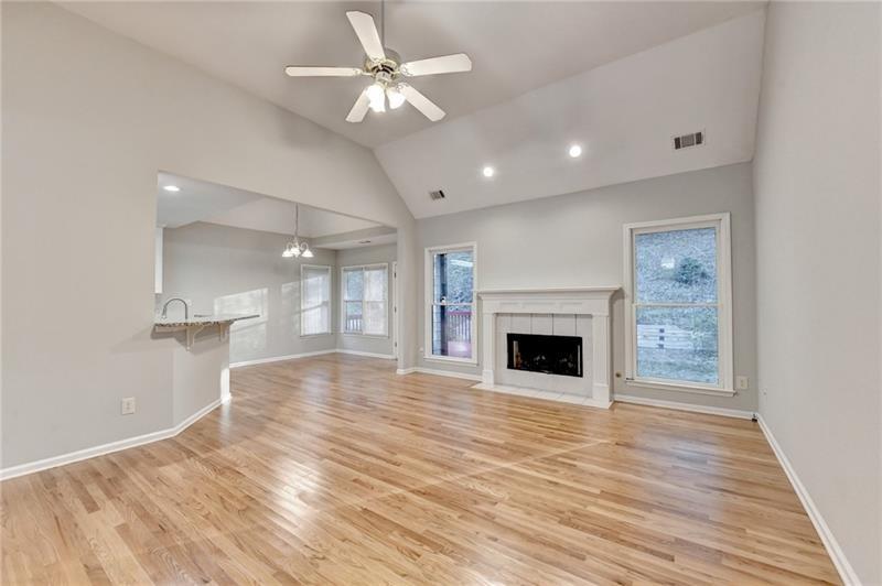 655 Golden Meadows Lane Suwanee, GA 30024 - Photo 13 of 73 a view of an empty room with wooden floor fireplace and a window